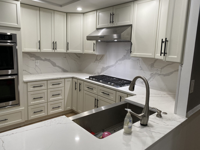 Elegant kitchen remodel with white shaker cabinets, quartz countertops, marble backsplash, stainless steel appliances, and farmhouse sink in PA