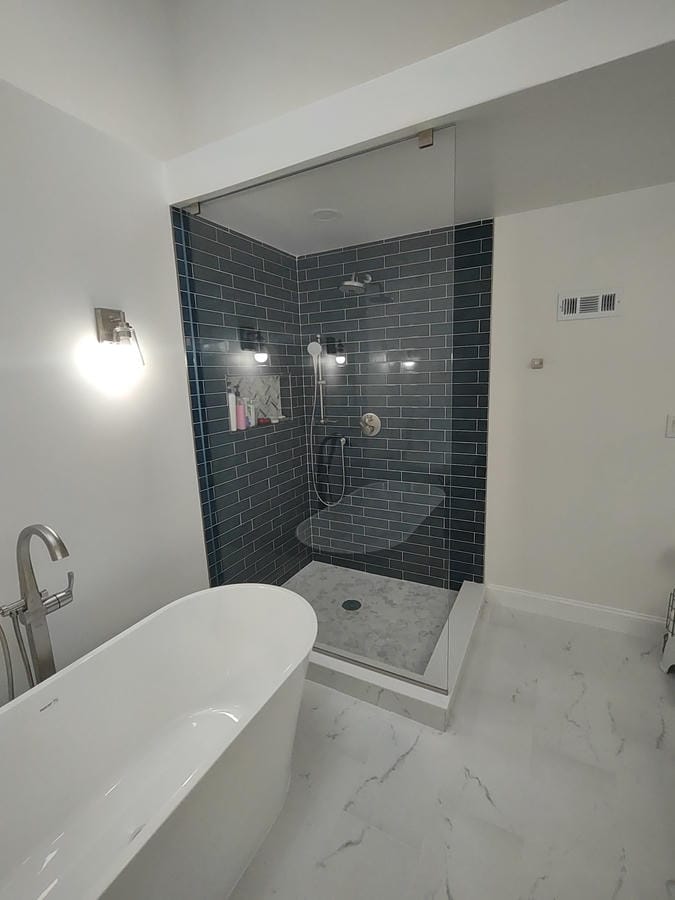 Teal tiled walk-in shower beside a dark vanity