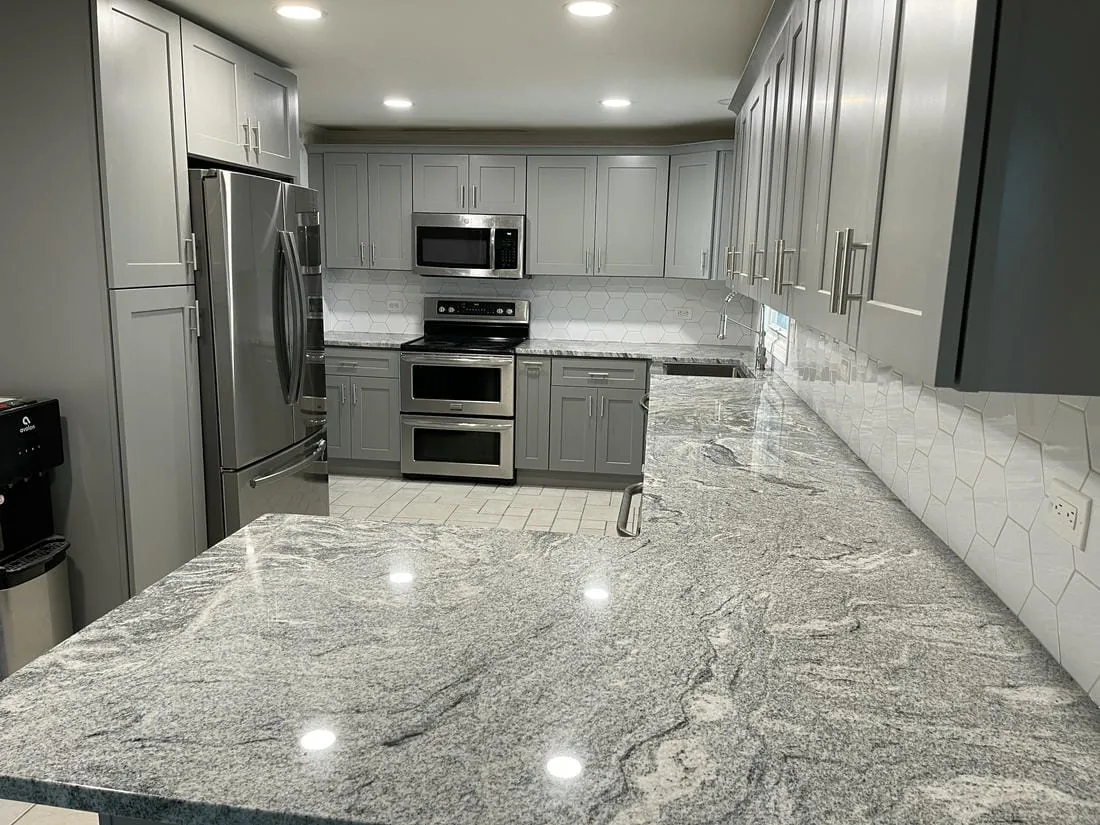 White kitchen remodel with an island and gray subway tile