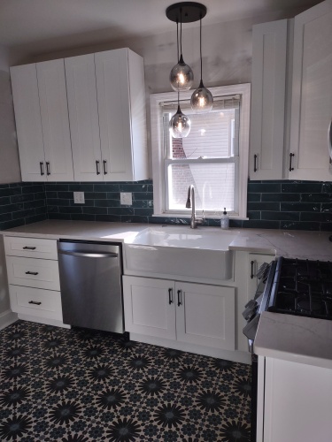White kitchen remodel with an island and gray subway tile
